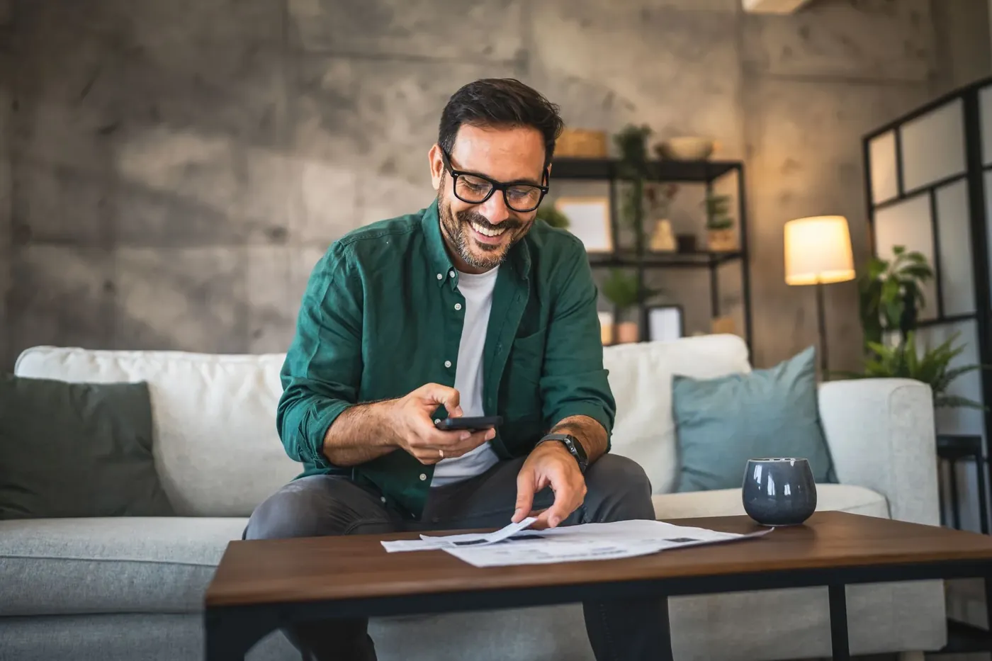 Smiling man reviewing paperwork on his couch