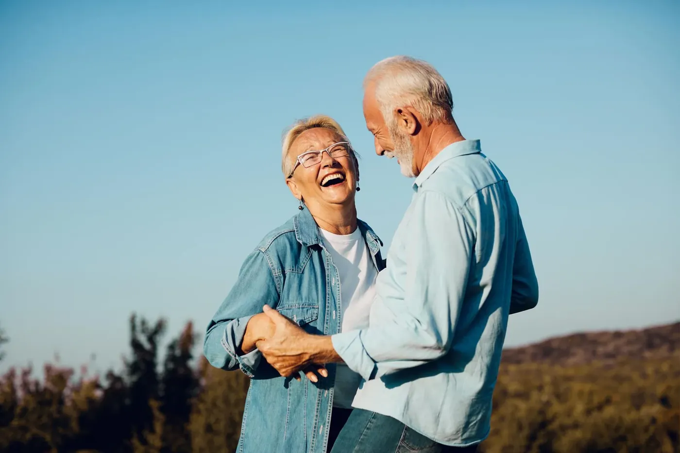 Senior couple laughing and dancing outdoors